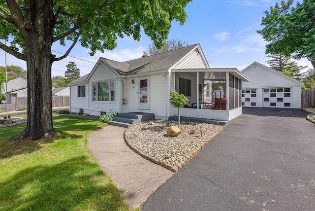 single story home with a sunroom, roof with shingles, and a garage
