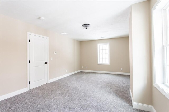 unfurnished room with carpet and baseboards