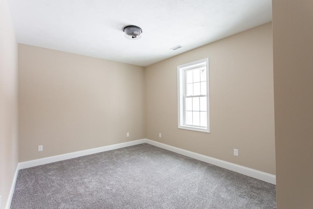 unfurnished room featuring baseboards, visible vents, and carpet flooring