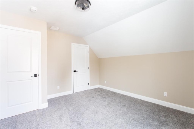 bonus room with carpet floors, baseboards, and vaulted ceiling