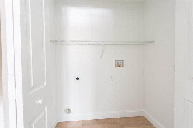 clothes washing area with washer hookup, light wood-style flooring, hookup for an electric dryer, laundry area, and baseboards