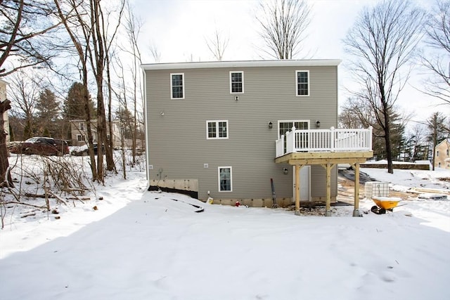 snow covered house featuring a deck