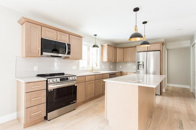 kitchen featuring light brown cabinets, stainless steel appliances, and a sink