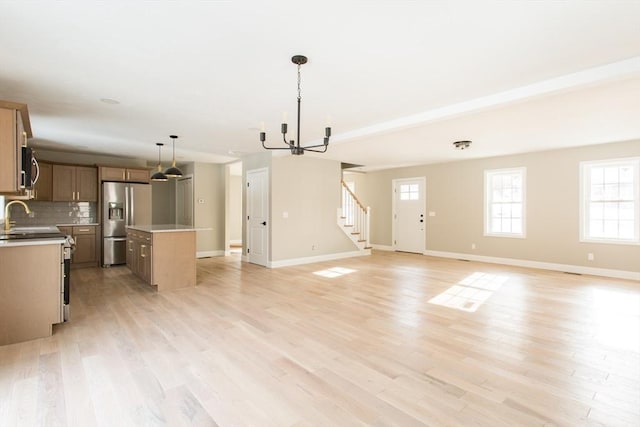 kitchen with open floor plan, a kitchen island, stainless steel fridge, and decorative backsplash