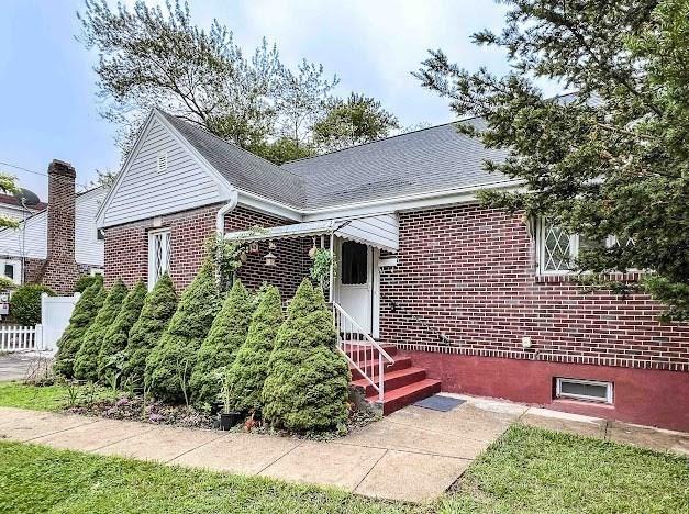 26 Beulah St, Framingham, MA 01701 - view of front of property with brick siding, entry steps, and roof with shingles