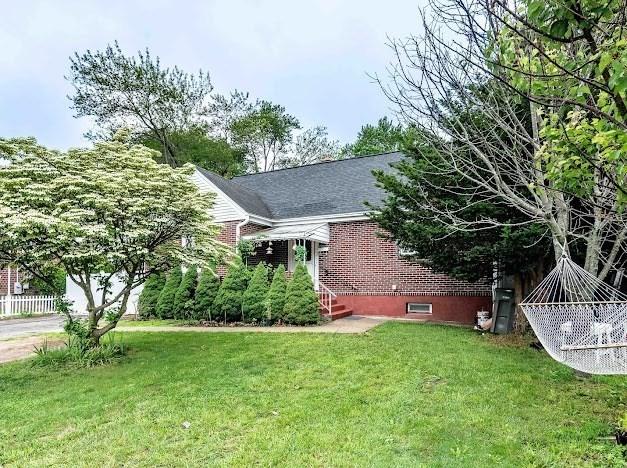 26 Beulah St, Framingham, MA 01701 - view of home's exterior featuring roof with shingles and brick siding