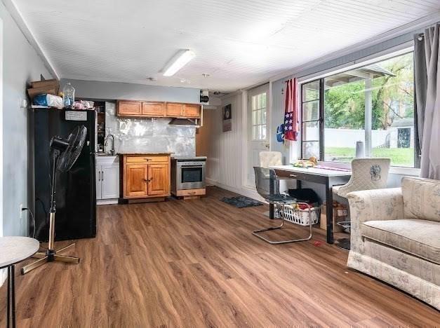 26 Beulah St, Framingham, MA 01701 - kitchen featuring freestanding refrigerator, range, dark wood-style flooring, brown cabinetry, and decorative backsplash