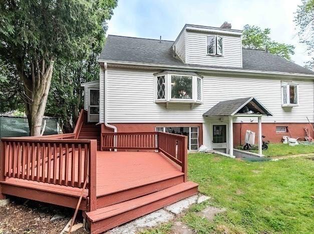 26 Beulah St, Framingham, MA 01701 - rear view of house with a lawn, a chimney, a wooden deck, and roof with shingles