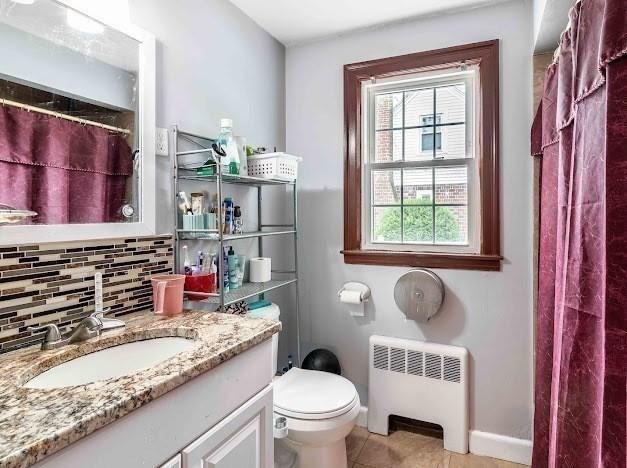 26 Beulah St, Framingham, MA 01701 - full bathroom featuring radiator, vanity, tile patterned floors, tasteful backsplash, and curtained shower