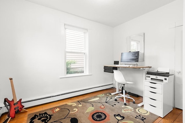 home office featuring baseboard heating and wood finished floors