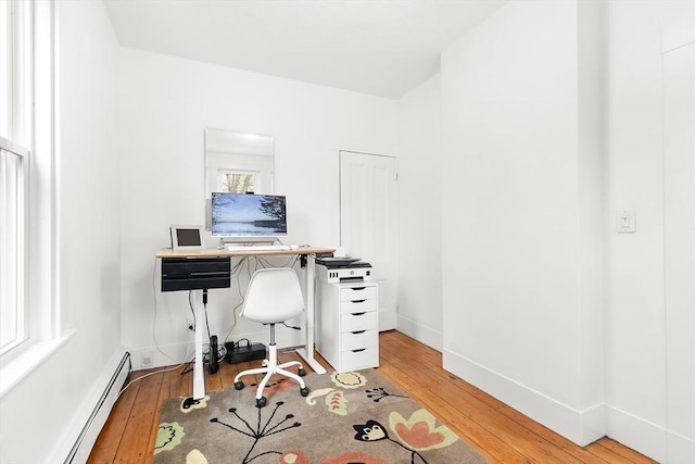 home office featuring baseboards, light wood-type flooring, and a baseboard radiator