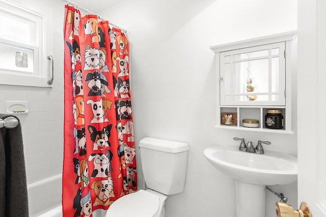 bathroom featuring a sink, shower / tub combo, a healthy amount of sunlight, and toilet