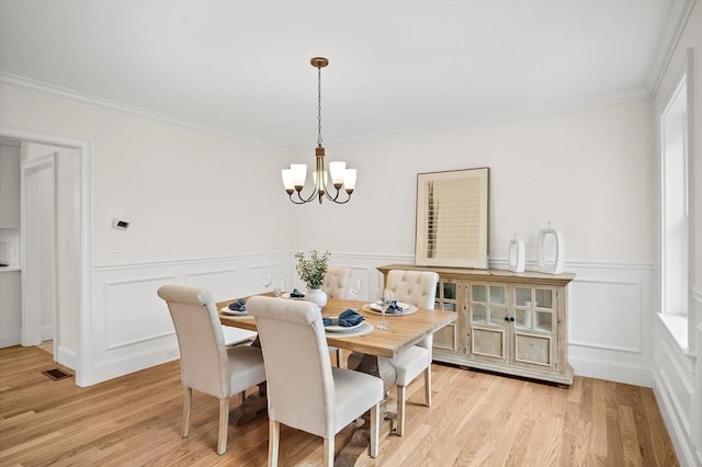 7 Locust St, Woburn, MA 01801 - dining space with a chandelier, light wood-type flooring, ornamental molding, wainscoting, and a decorative wall