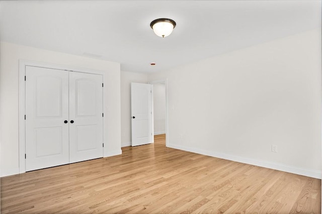 7 Locust St, Woburn, MA 01801 - unfurnished bedroom with light wood-style flooring, baseboards, and a closet