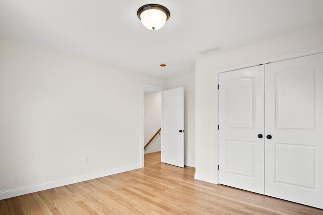 7 Locust St, Woburn, MA 01801 - unfurnished bedroom with baseboards, light wood-type flooring, and a closet