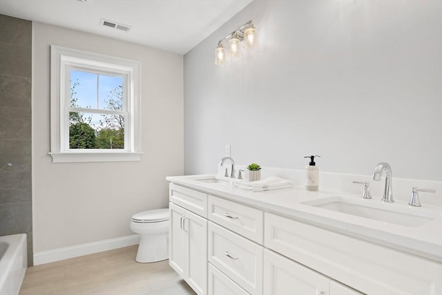 7 Locust St, Woburn, MA 01801 - bathroom featuring toilet, baseboards, double vanity, a bath, and wood finished floors