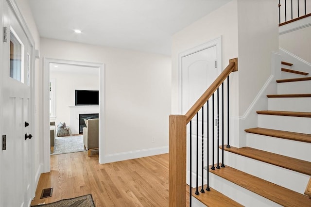 7 Locust St, Woburn, MA 01801 - stairway with wood finished floors, baseboards, a high end fireplace, and recessed lighting