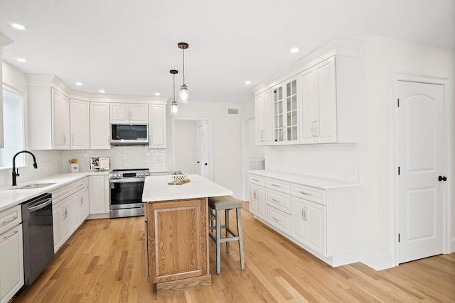 7 Locust St, Woburn, MA 01801 - kitchen featuring stainless steel appliances, a sink, white cabinetry, and recessed lighting