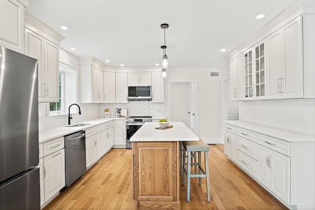 7 Locust St, Woburn, MA 01801 - kitchen featuring stainless steel appliances, a sink, light wood-type flooring, white cabinetry, and recessed lighting