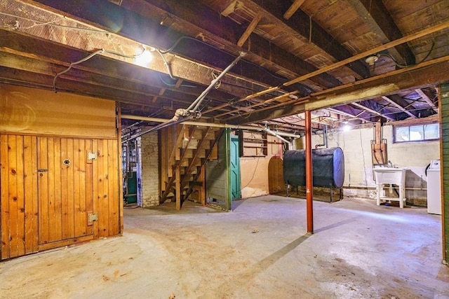 basement with separate washer and dryer, sink, and wooden walls