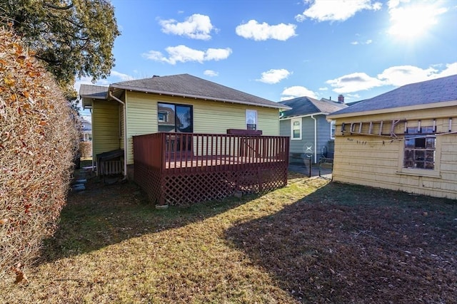 back of property with a lawn and a wooden deck