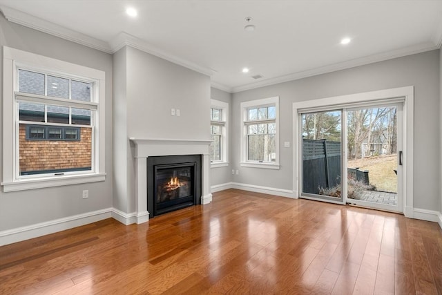 unfurnished living room featuring hardwood / wood-style floors and crown molding