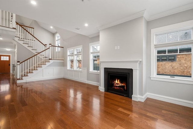 unfurnished living room featuring wood-type flooring and crown molding