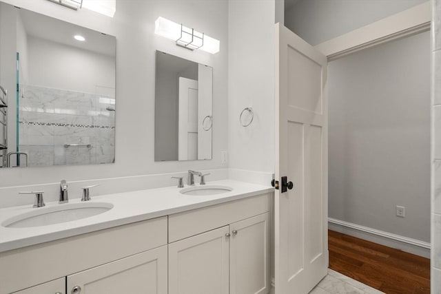 bathroom with a shower with door, vanity, and hardwood / wood-style flooring