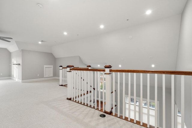 corridor with lofted ceiling, light colored carpet, and a healthy amount of sunlight