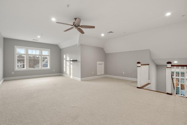 unfurnished living room with ceiling fan, vaulted ceiling, and light colored carpet