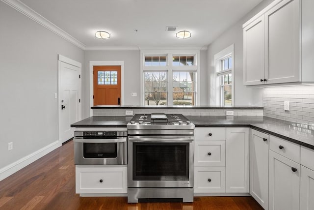 kitchen with white cabinets, ornamental molding, backsplash, dark hardwood / wood-style flooring, and appliances with stainless steel finishes