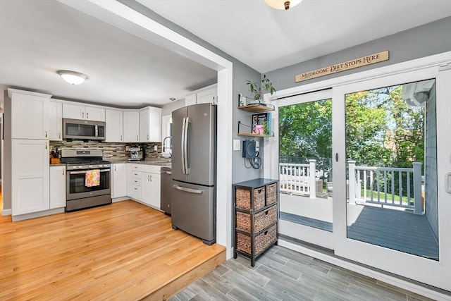 49 Pinehurst Ave, Methuen, MA 01844 - kitchen with stainless steel appliances, white cabinetry, light wood-style floors, and backsplash