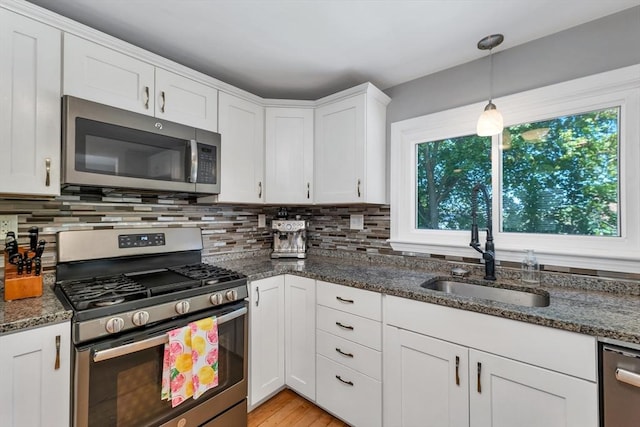 49 Pinehurst Ave, Methuen, MA 01844 - kitchen featuring appliances with stainless steel finishes, a sink, white cabinets, dark stone countertops, and decorative backsplash