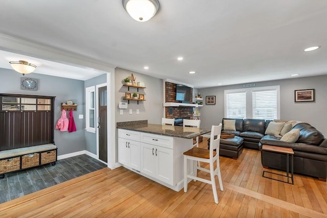 49 Pinehurst Ave, Methuen, MA 01844 - kitchen with light wood-style floors, white cabinets, a breakfast bar, a peninsula, and open floor plan