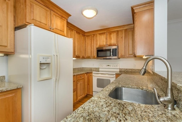 kitchen with sink, white appliances, and light stone countertops