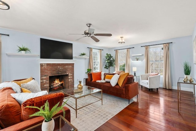 living room featuring a brick fireplace, baseboards, a ceiling fan, and hardwood / wood-style floors