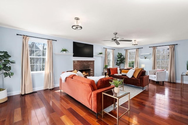 living room featuring dark wood-style floors, a fireplace, a ceiling fan, and baseboards