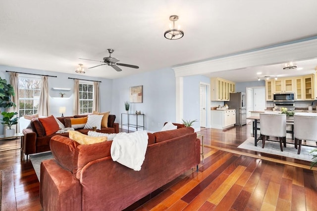 living area with ceiling fan and dark wood finished floors