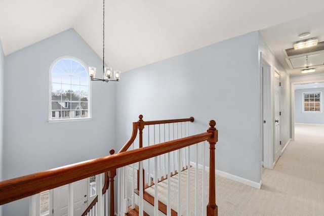 hallway featuring carpet floors, lofted ceiling, attic access, an upstairs landing, and a wealth of natural light