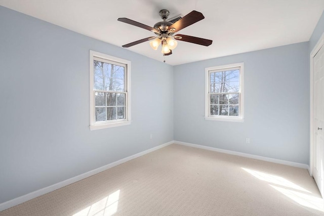 unfurnished bedroom with baseboards, multiple windows, light carpet, and a closet