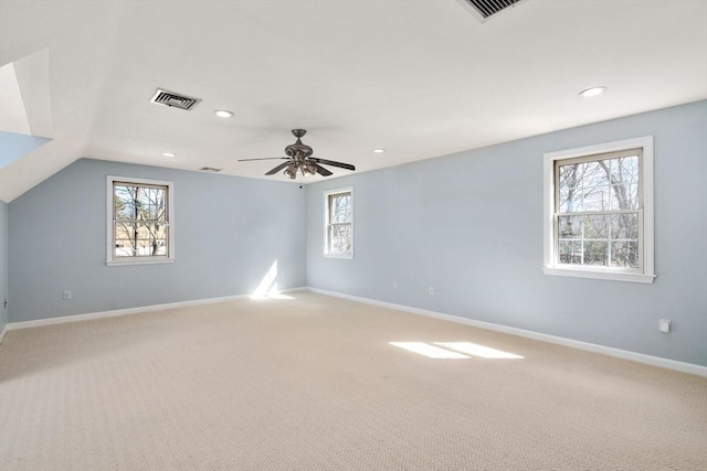 unfurnished room featuring baseboards, a wealth of natural light, and light carpet