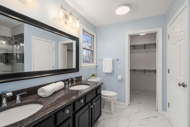 bathroom with a sink, marble finish floor, a stall shower, and double vanity