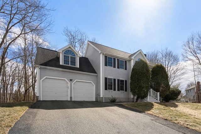 view of front of property with aphalt driveway, a garage, and roof with shingles