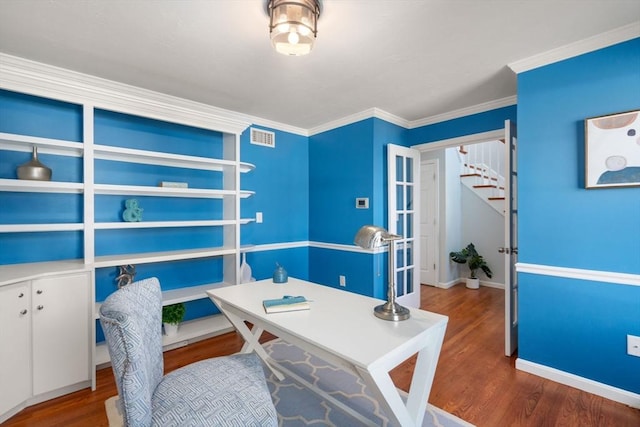 office area with visible vents, crown molding, baseboards, and wood finished floors