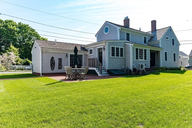 rear view of property featuring a patio and a lawn