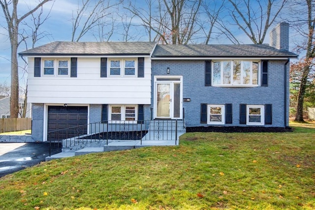 raised ranch with a garage and a front yard