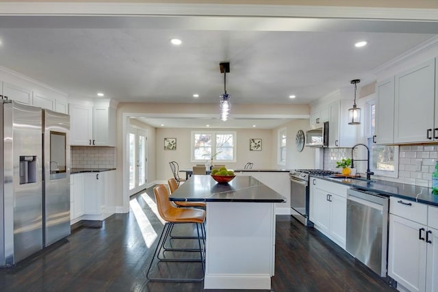 kitchen with dark hardwood / wood-style flooring, sink, stainless steel appliances, and hanging light fixtures