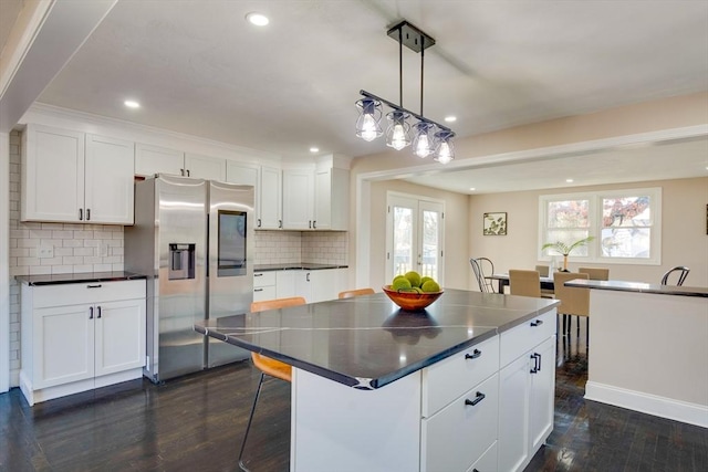 kitchen featuring white cabinets, a center island, and stainless steel fridge with ice dispenser