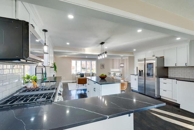 kitchen featuring hanging light fixtures, stainless steel appliances, a kitchen island, dark hardwood / wood-style floors, and white cabinets