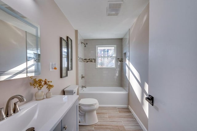 full bathroom with vanity, toilet, and tiled shower / bath